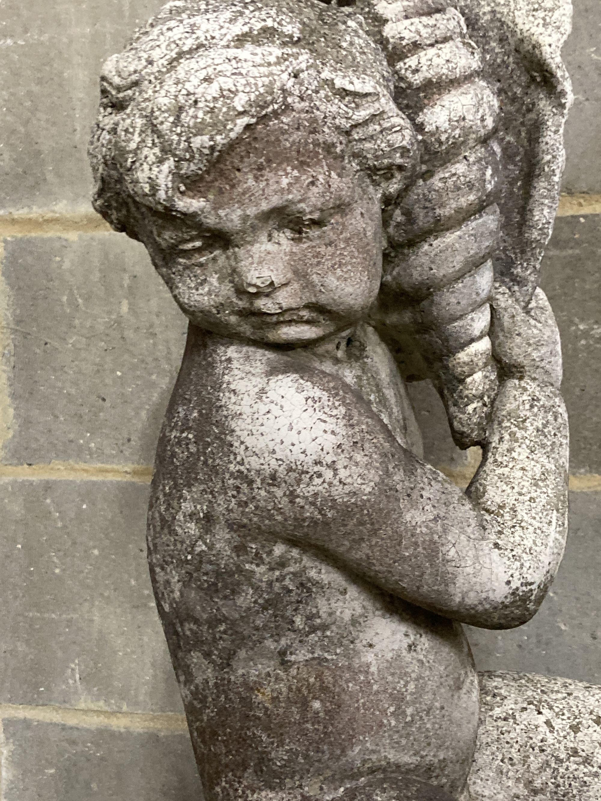 A reconstituted stone garden figure on plinth, boy with a sea shell, height 154cm
